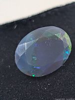 Close-up of the opal showing oval faceted cut and play-of-color