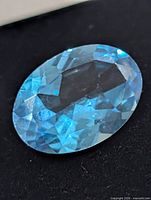 close-up of oval blue topaz showing facets