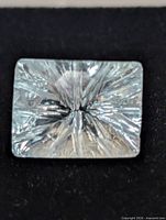 Rectangular light blue gemstone showing starburst fantasy cut face up