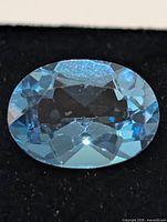 Top view of oval blue topaz showing facets and color