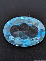 top view of oval blue topaz gemstone showing facets and clarity