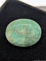 Top view of oval emerald gemstone on black background