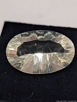 Oval pale green faceted gemstone on black background