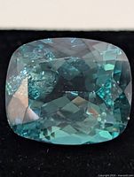 Front angled view of loose cushion-cut green topaz
