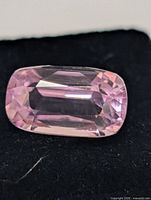 Close-up of faceted light pink kunzite on black background