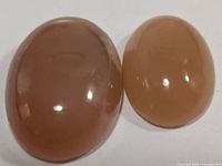 Top view of both moonstone cabochons showing color and polish