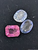 Close-up of three sapphires showing colors and cuts