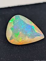 Close-up of pear cabochon opal showing play of color