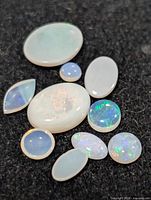 Assorted opal cabochons on black background