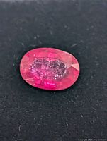 Close-up of the oval ruby showing faceting and internal characteristics