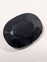 Front view of oval faceted dark sapphire