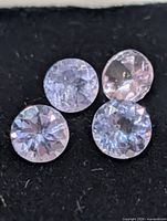 Four tanzanite gemstones on black surface