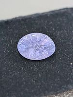 close view of loose oval tanzanite on black background