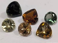 Six assorted faceted tourmaline stones in various colors and cuts