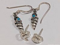 Both earring pairs laid out: dangle pair with turquoise, stud pair with butterfly backs