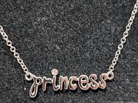 Close-up of pendant showing script text and diamond accent