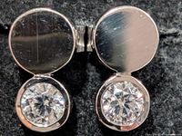 Front view of both earrings showing polished upper discs and bezel-set stones