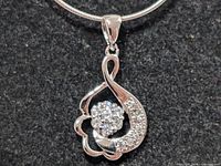 Close-up of pendant showing CZ cluster and pavé accents