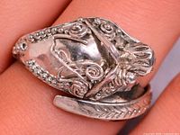 Front view of silver wrap ring showing ornate face detail