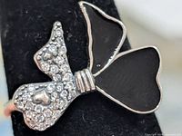 Front view of bow ring showing onyx wings and CZ-set wing with heart accent