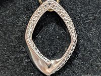 Front view of silver rhombus pendant with diamond accents