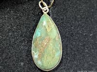 Front view of teardrop Peruvian opal pendant in silver bezel