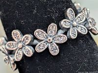 Close-up of flower motifs with stone accents on ring