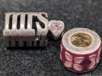 Both silver beads side by side on dark background