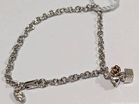 Full view of silver bracelet with charm and clasp