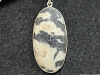 Front view of oval zebra jasper pendant in silver setting