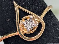 Front view of ring showing diamond and teardrop bezel