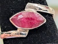Front view of silver ring showing marquise dyed ruby stone in bezel setting