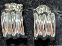 Front view of both ribbed sterling silver half-hoop earrings showing 925 stamp