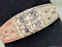 Close-up of ring face showing four clear stones and bead detail