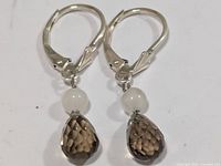 Front view showing both earrings, quartz drops, white beads, silver lever-backs