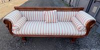 Front view of mahogany Duncan Phyfe style sofa with striped upholstery and pillows