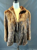 Full frontal view of brown fur jacket on mannequin