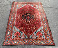 Full view of hand-knotted rug showing entire pattern and wear