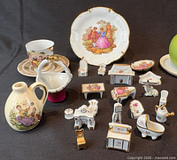 Group of Limoges porcelain miniatures showing all items including plate, cup, saucer, pitcher, basket, miniature furniture and animal figure