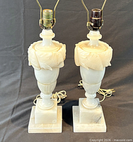 Front view of both alabaster lamps showing urn carving and bases