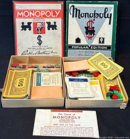 Both Monopoly travel sets open showing boxes, money, cards, houses, hotels