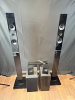 Pair of tall Samsung floor speakers with three additional smaller speaker units in front