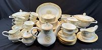 Full service set displayed including plates, bowls, cups, teapot and serveware