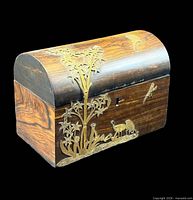 Three-quarter view of wooden domed caddy showing brass overlay and grain