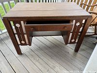 Front view of oak mission desk showing drawer and decorative side panels