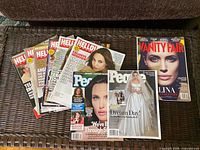 Nine Angelina Jolie magazines arranged on wicker surface; covers visible