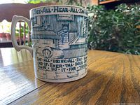 Side view of mug showing transferware scene and motto text