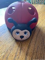 Front view of ceramic ladybug holder showing face and red shell