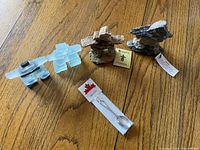 All four inukshuk figurines and Tobermory collector spoon laid out on wooden surface