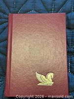 Front cover of burgundy hardcover with Pegasus emblem